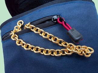 Fototapeta na wymiar gold metal chain in a small blue bag. brass chain. fashion accessories. chain and lock