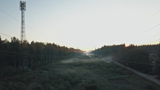 High voltage power line in the forest in fog in the morning