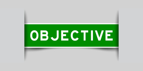 Inserted green color label sticker with word objective on gray background