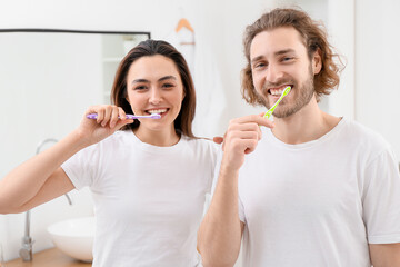 Lovely couple brushing teeth in bathroom