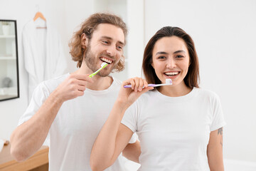 Lovely young couple brushing teeth in bathroom