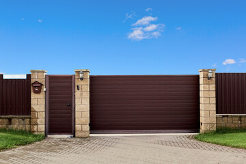 Brown metal profile fence with block posts. Entry group with gate, flashlight and postbox. Opaque...