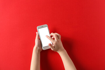 Child using modern mobile phone on red background