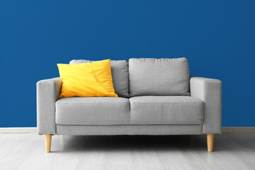 Stylish sofa near blue wall