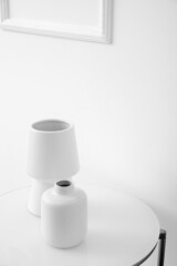 White vases on table near light wall