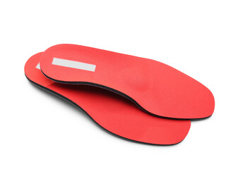 Pair of red orthopedic insoles on white background
