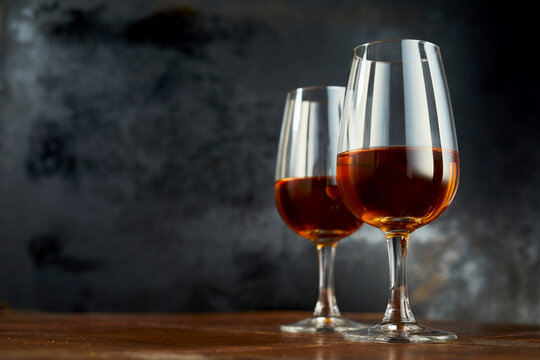 Shiny wineglasses with sherry drink laced on wooden counter