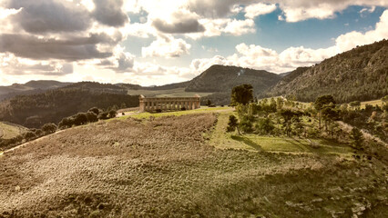 Aerial view of the Temple of Segesta in the countryside of Sicily, Italy against sunset cloudy sky
