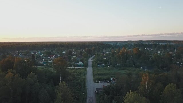 The road to the Russian village in the forest woods on a foggy morning in the light of the rising sun
