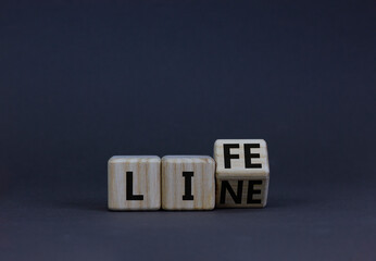 Lifeline, line of life symbol. Turned the wooden cube and changed the concept word Life to Line. Beautiful grey table grey background. Business lifeline, line of life concept. Copy space.