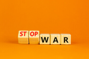 Stop war symbol. Turned cubes and changed concept words War to Stop war. Beautiful orange table orange background. Business and stop war concept. Copy space.