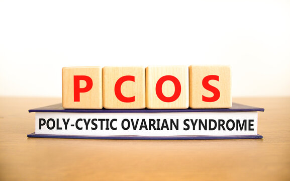 PCOS poly-cystic ovarian syndrome symbol. Concept words PCOS poly-cystic ovarian syndrome on cubes on book on a beautiful white background. Medical PCOS poly-cystic ovarian syndrome concept.