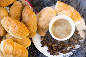 A cup of coffee and delicious croissants on a fluffy blanket