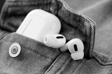 White wireless headphones on denim, music device
