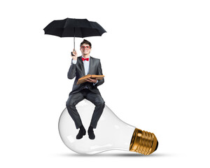 A young businessman sits on a light bulb