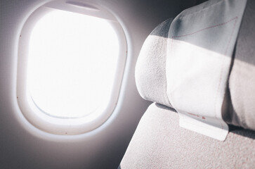 Photo of sunlight peering through a plane window on a seat