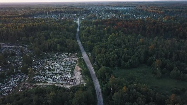 The road to the Russian village in the forest woods on a foggy morning in the light of the rising sun