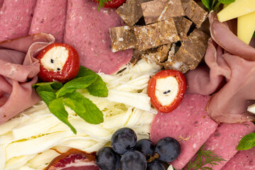 Cold Smoked Meat Plate, antipasto set platter wooden plate. Antipasto board with sliced meat, ham, salami, cheese. Close up