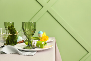 Table served for Easter celebration near green wall, closeup