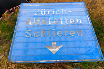 Blue vintage direction road sign laying on the ground at City of Zürich on a cloudy spring day....