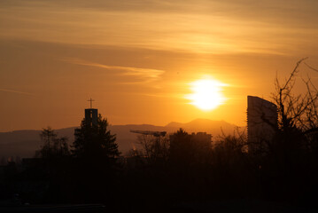 Sunrise on a beautiful spring day at Zürich Schwamendingen with crane, skyscraper and the Swiss Alps in the background. Photo taken March 11th, 2022, Zurich, Switzerland.