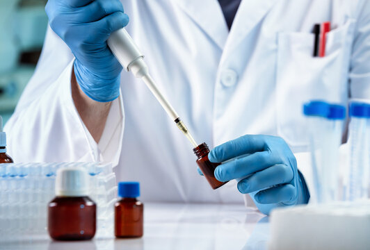Scientific researcher pipetting a sample of chemical liquids into test tube. Research engineer working with liquids on the development of new drugs