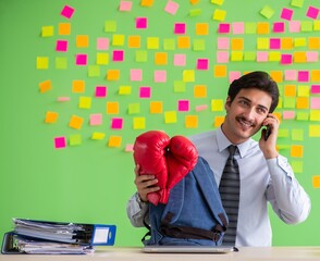 Man with boxing gloves in the office with many conflicting prior