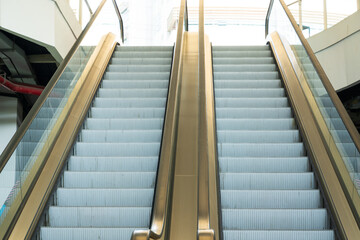 Empty escalator for lifting ladder in shopping mall.Modern luxury escalators with staircase at public airport.