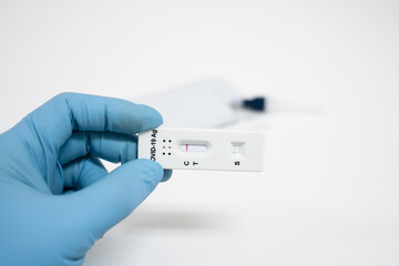 Medical technician wearing blue gloves taking a swab for corona virus sample from potentially infected.Covid-19 laboratory test.Man using rapid antigen test kit for self test .