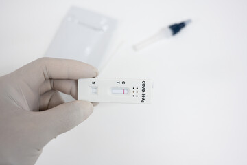 Covid-19 laboratory test.Man using rapid antigen test kit for self test at home.Antigen test kit for self collect nose swab on white background.COVID-19 coronavirus pandemic protection concept