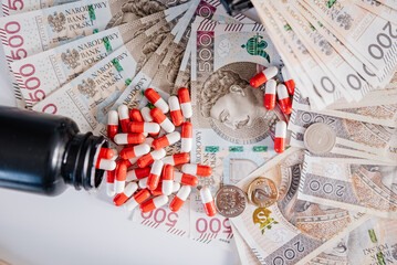Wysypane leki z opakowania na tle pieniędzy
