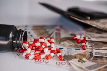 Wysypane leki z opakowania na tle pieniędzy