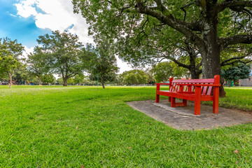 Beautiful red bench in a green park - Powered by Adobe