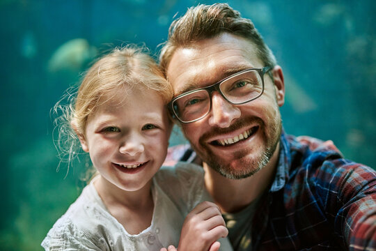 Making the experience last forever. Portrait of a father and his little daughter taking a selfie together at an aquarium.
