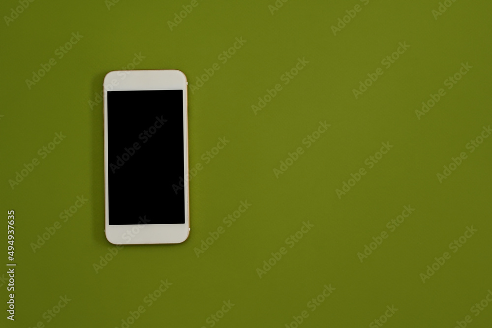 Poster top view flat lay of a smartphone with blank screen on a green background with a lot of empty space 