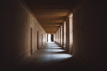 Closeup of a long hallway with lights between columns - obrazy, fototapety, plakaty