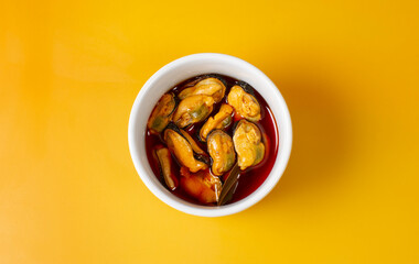 bol de mejillones en escabeche sobre fondo naranja