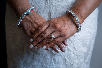 Closeup of a South Asian bride's hands covered in beautiful henna and jewelry