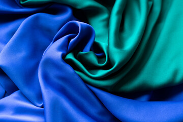 Blue and green fabric twisted into a common spiral in the center