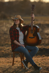 cowgirl with guitar at sunset