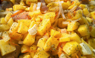 Vegetable stew with potatoes, meat and herbs in a white ceramic baking dish. Cooking homemade food.