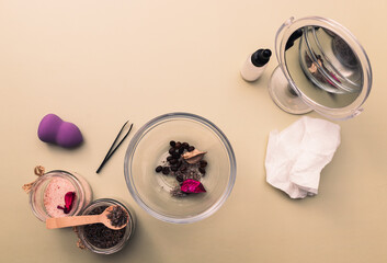 DIY homemade cosmetics. table with randomly arranged ingredients. salt, lavender, sponge, tweezers, glass container with cosmetic mixture on olive background.