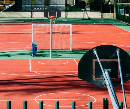 View Of Tree Shadows Dropping On An Empty Basketball Field In Sunlight