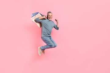 Photo of pretty lucky retired man wear grey shirt jumping rising fist shoppers empty space isolated...