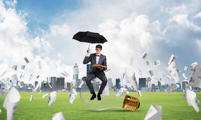 young businessman with an umbrella and a book