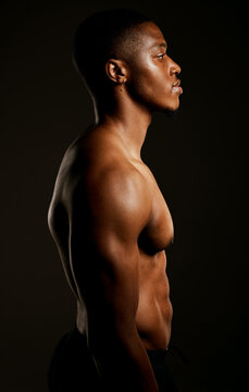 Every pound of muscle is pure man. Studio shot of a fit young man posing against a black background.