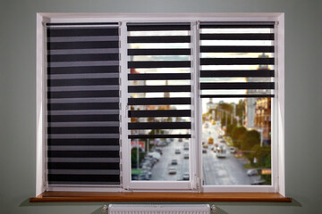 Window roller duo system day and night on woden windowsill with view for very beautiful city