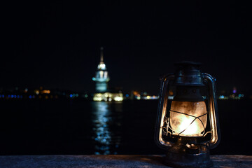 yellow lantern behind maiden tower near the sea in the night