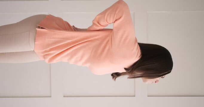 Vertical video of woman massaging her injured lower back