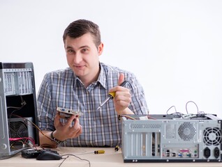 Young technician repairing computer in workshop